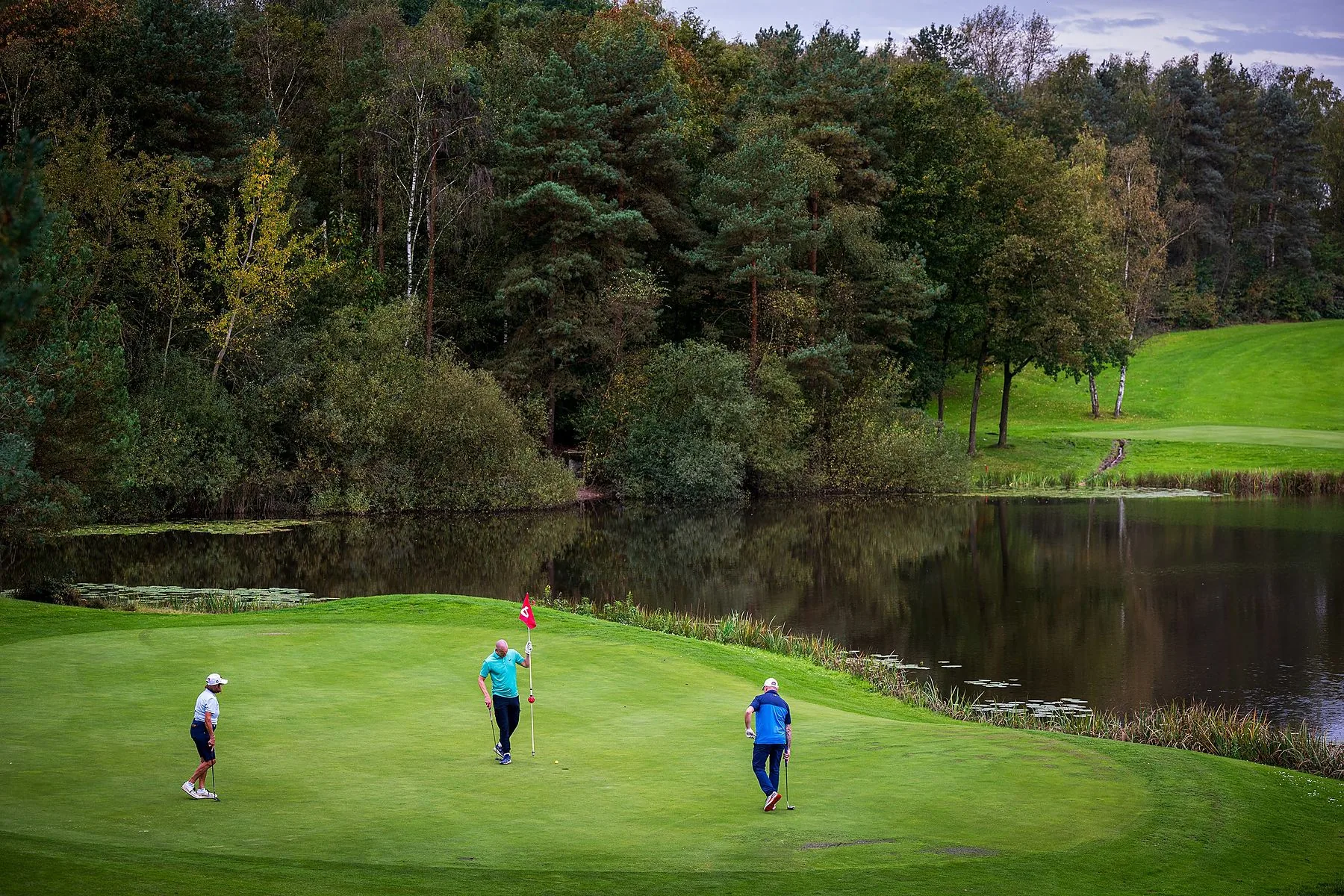 Golfers op de green bij een vijver