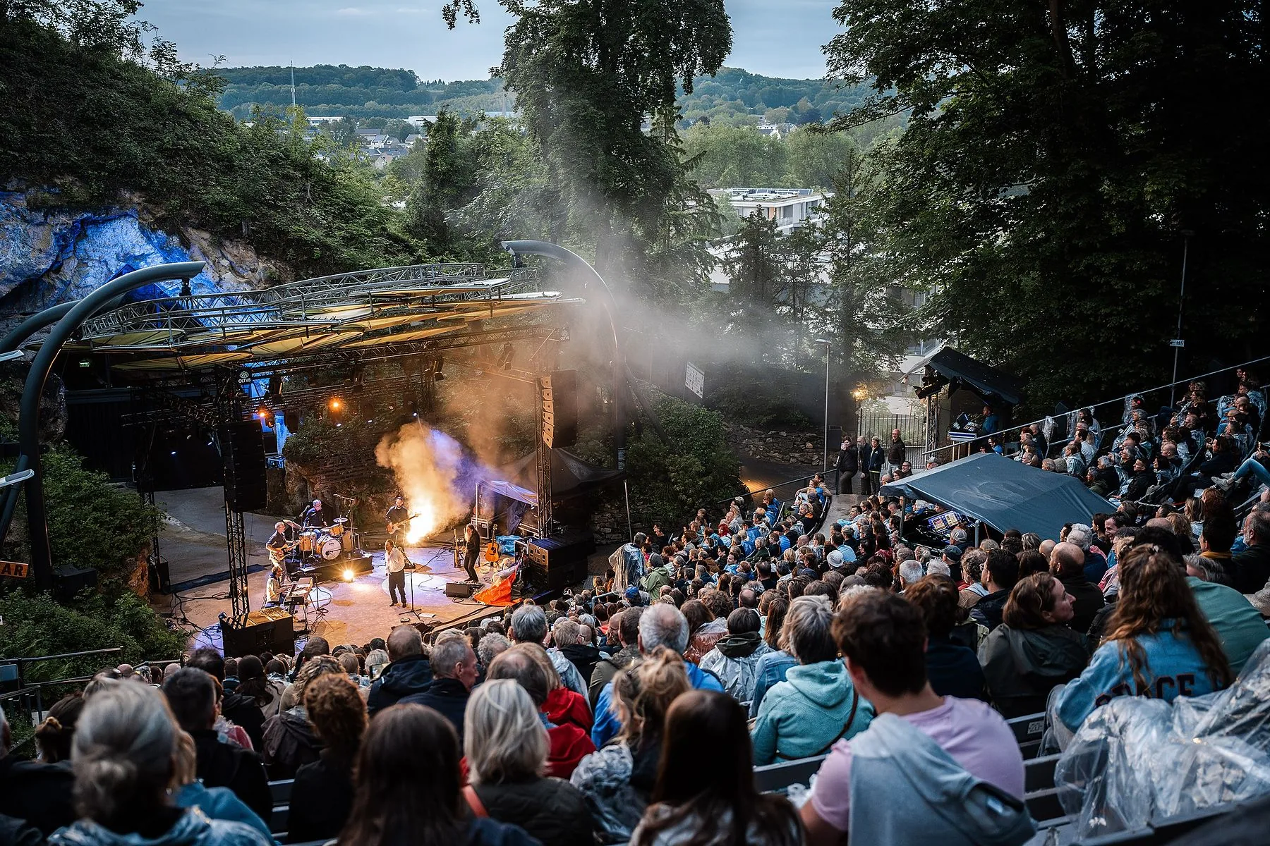 Openluchtconcert in de schemering met een volle tribune